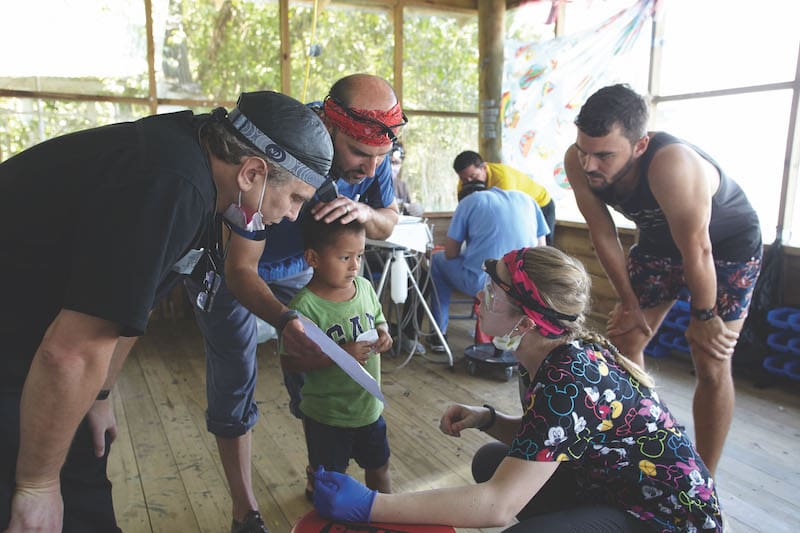 group of kids learning how to brush teeth with a stuffed animal